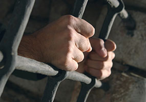 prisão, mão na grade - Shutterstock