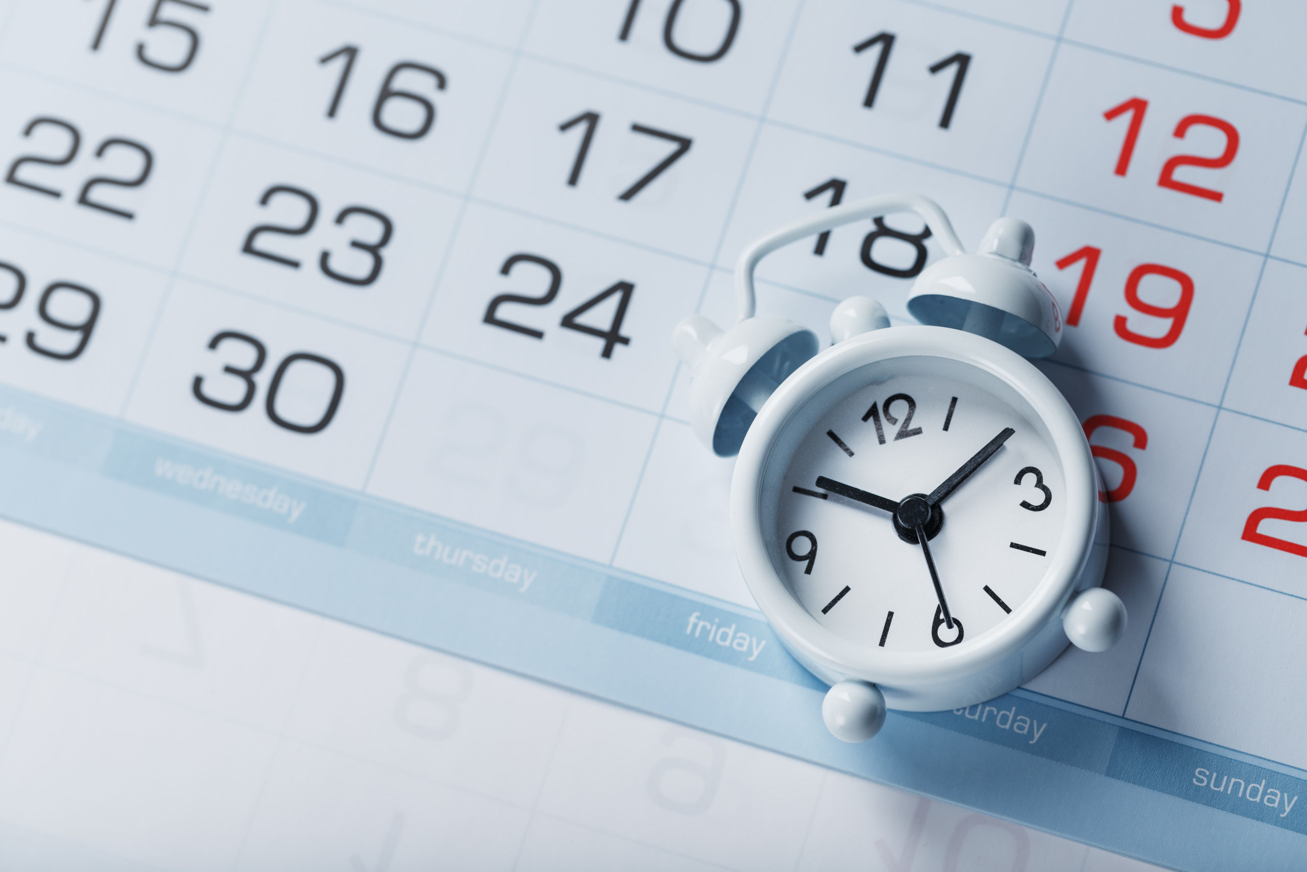 Relógio despertador sobre calendário